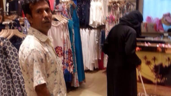 صورة لسعودية تنظف محلاً بأمر من بائع آسيوي