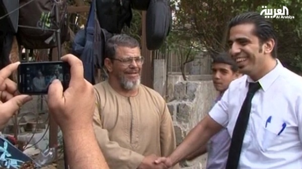 شبيه مرسي يلتقط الصور التذكارية مع المارة في حي العباسية