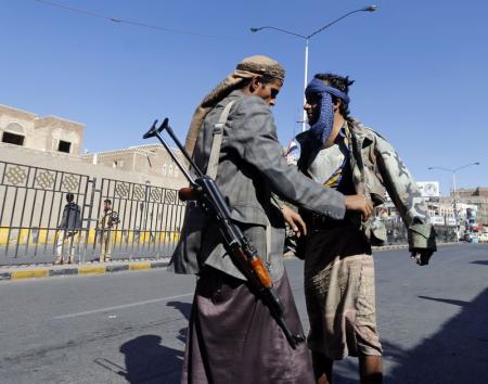 أحد عناصر جماعة الحوثي يفتش رجلا عند نقطة أمنية في صنعاء - رويتر
