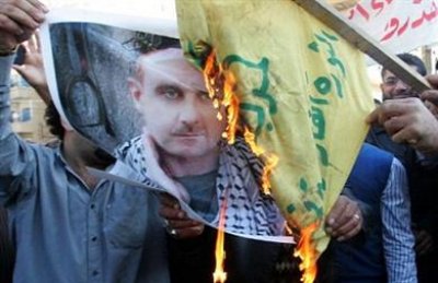 متظاهرون يحرقون صورة لبشار الاسد وراية حزب الله