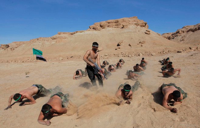 متطوعون عراقيون يتلقون تدريبات على الزحف في صحراء النجف