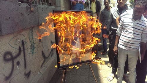 فنان يمني يحرق لوحاته التشكيلية احتجاجا على إلغاء الحوثيين لمعرضه الفني (صورة)