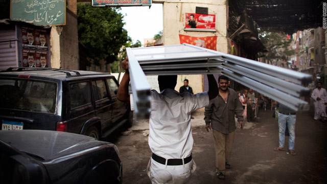 رجل شرطة يحمل منصات الانتخاب إلى أحد مراكز الاقتراع بالقاهرة