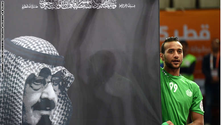لاعب كرة اليد السعودي عباس الصفار يرفع لافتة تحمل صورة للملك الر
