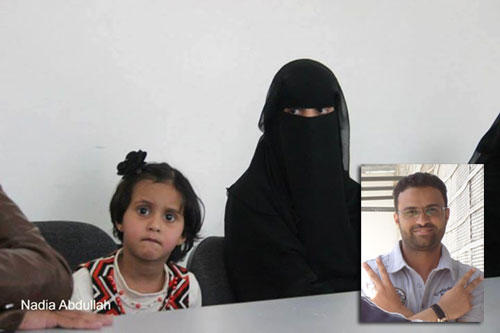 زوجة وابنته المعتقل ابراهيم الحمادي وفي الإطار صورة إبراهيم داخل