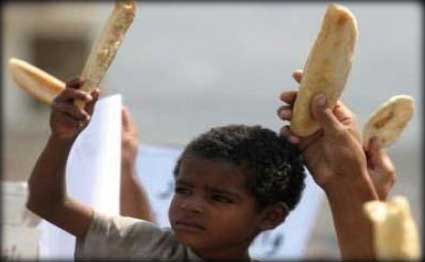 طفل يمني يرفع الخبز تعبيرا عن الفقر المنتشر باليمن.. صورة أرشيفي
