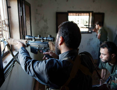 مقاتلون سوريون يشتبكون مع قوات النظام بالقرب من إدلب