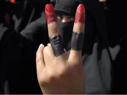 متظاهرة يمنية تشير بعلامة النصر