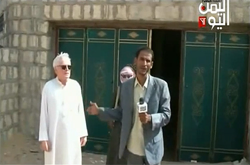 مراسل قناة اليمن اليوم يتحدث إلى الكاميرا وبجواره المختطف الألما