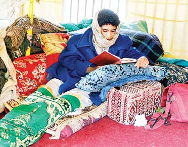 شاب في ساحة التغيير يقرأ القرآن في خيمته