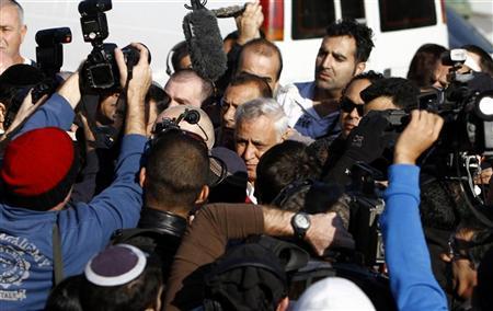 الرئيس الإسرائيلي السابق موشي قصاب (في الوسط) لدى خروجه من منزله