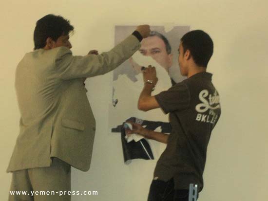 طلاب في جامعة صنعاء يقومون بتمزيق وإزالة صور علي عبدالله صالح من